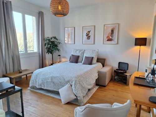 um quarto com uma cama e um sofá em Appartement hyper centre, cathédrale, fibre em Lisieux