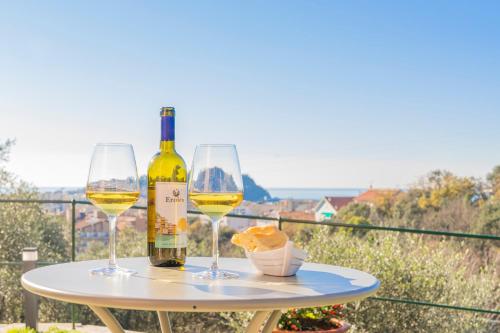 塞斯特里萊萬泰的住宿－Villa Chicchi - Sestri Levante，一张桌子,上面放着两杯白葡萄酒和面包