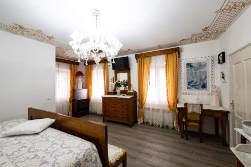 sypialnia z łóżkiem, komodą i biurkiem w obiekcie Palazzo Cervesato: Camera Regina Margherita w mieście Santo Stefano di Cadore