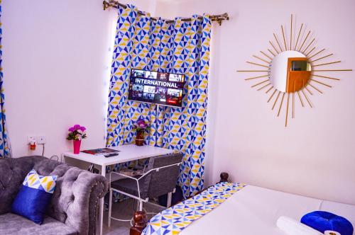 um quarto com um sofá, uma mesa e um espelho em Roma Stays - Classy Studio Apartment in Nyali ( Opp Shell Links Road) em Mombasa