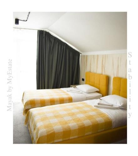 two beds sitting next to each other in a room at Aparthotel "Mayak Yablunytsia" in Yablunytsya