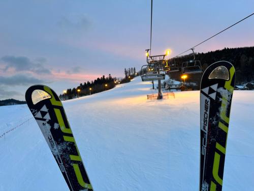 a pair of skis in the snow next to a ski lift at Domki Piwniczna in Piwniczna