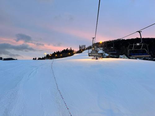 a snow covered slope with a ski lift on it at Domki Piwniczna in Piwniczna