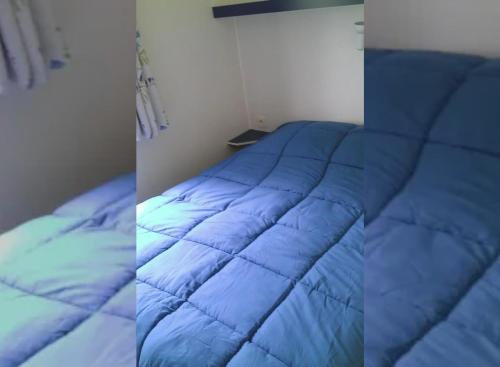 2 Bilder eines blauen Bettes in einem Zimmer in der Unterkunft Mobil Home 4 personnes 208 in Mens