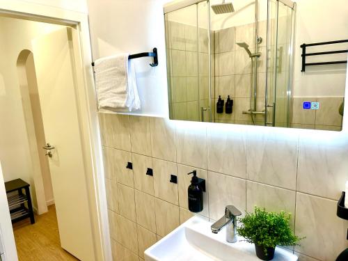 y baño con lavabo y espejo. en Frisch renoviert, Dschungel Apartment, 4 Betten, Smart TV, Sonos, nahe Messe Düsseldorf, Helios Klinik, Innenstadt, en Krefeld