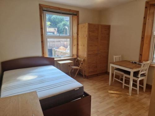 um quarto com uma cama, uma secretária e uma mesa em Bright studio apartment Highgate em Londres