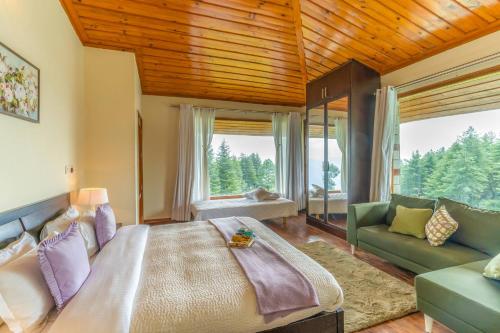 a bedroom with a large bed and a couch at StayVista at The Woods in Chail