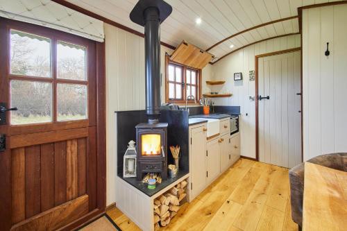 a kitchen with a wood stove in the middle at Host & Stay - Black Mountains Bespoke Breaks in Bronllys