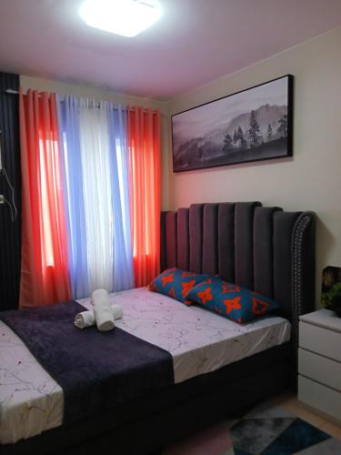 a bedroom with a bed with red and blue curtains at Entire 2BR condo Centro Spatial Downtown in Davao City