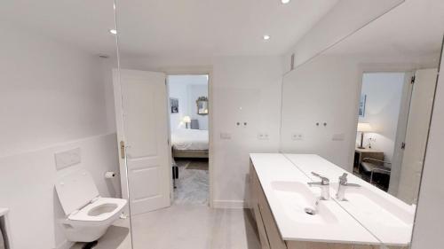 Baño blanco con lavabo y aseo en Modern Coastal Apartment Near Puerto Banús en Marbella