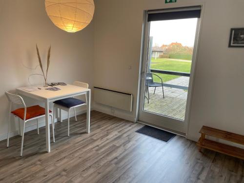 a room with a table and chairs and a sliding glass door at KragenæsHus in Torrig