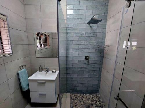 y baño con ducha, lavamanos y ducha. en Hide Away on 21, en Mossel Bay