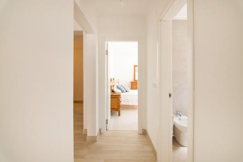 ein weißes Badezimmer mit Badewanne und ein Schlafzimmer in der Unterkunft Meggie Moo Beach House in Praia da Areia Branca