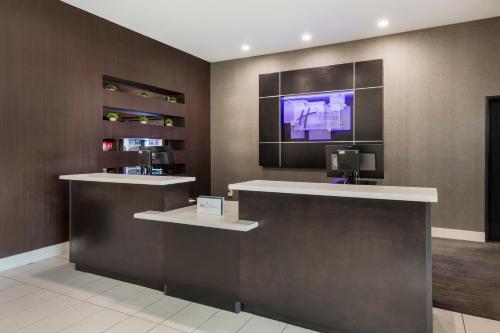 a lobby with a counter with a tv on the wall at Holiday Inn Express & Suites Anaheim Resort Area, an IHG Hotel in Anaheim