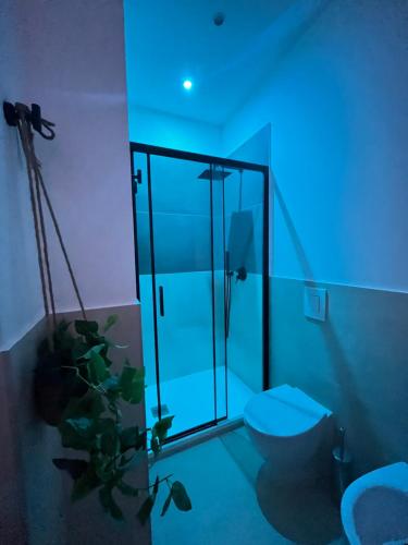baño con ducha y aseo con luz azul en Valguarnera Suites & Apartments, en Palermo