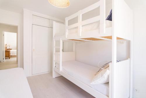 ein weißes Schlafzimmer mit weißen Regalen und einem Bett in der Unterkunft Meggie Moo Beach House in Praia da Areia Branca