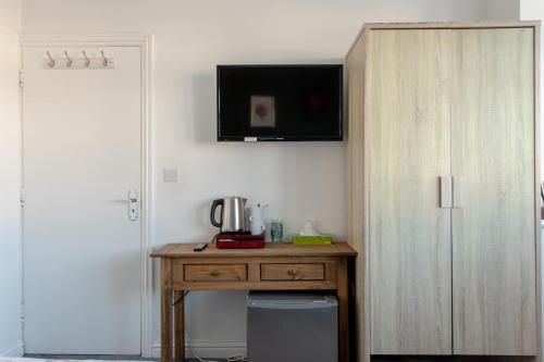 um quarto com uma secretária de madeira e um armário em Apple House Wembley em Barnet