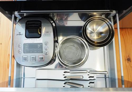 a toaster oven with several pans on top of it at とけとけ山荘 in Fujikawaguchiko