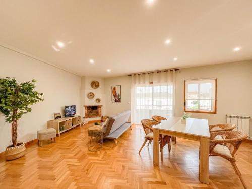 a living room with a table and chairs and a couch at Comfortable apartment in Viana do Castelo in Viana do Castelo