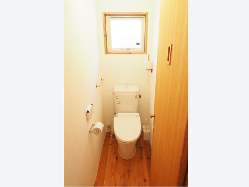 a small bathroom with a toilet with a window at とけとけ山荘 in Fujikawaguchiko