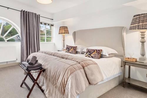 a white bedroom with a large bed and a window at Quintessential Apartment, The Coach house in Blockley