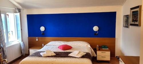 a bedroom with a blue wall and a bed at Hotel Bellavista Meublè in Monte Isola