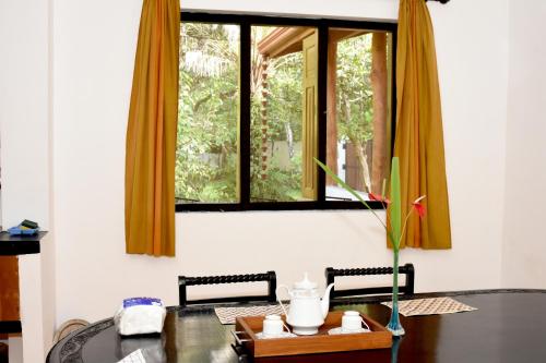 a dining room with a table and a window at Villa Polhena in Matara
