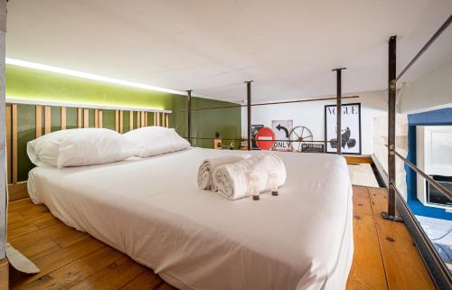 une chambre avec un grand lit blanc avec des serviettes dessus dans l'établissement Green Loft, à Montpellier