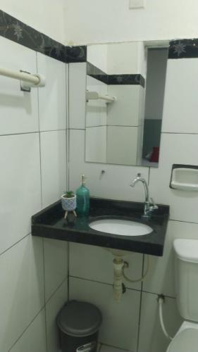 a bathroom with a sink and a toilet and a mirror at HOTEL CYSNE in Sobral