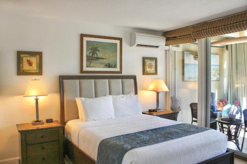 sypialnia z łóżkiem i 2 lampami oraz balkonem w obiekcie Kona Bali Kai #230 w mieście Kailua-Kona