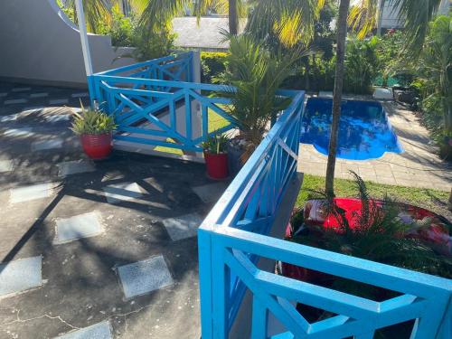 a blue fence in front of a pool with plants at Blue paradise Villa in Triolet