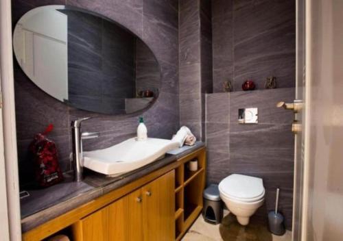 a bathroom with a sink and a toilet and a mirror at Superbe appartement à la corniche de Casablanca in Casablanca