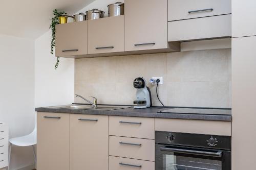 a kitchen with white cabinets and a sink at Cascina Conicchio - Metro Station - by Host4U in Brescia