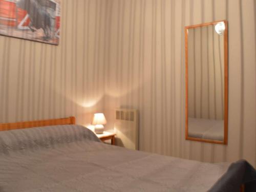 - une chambre avec un lit, un miroir et une lampe dans l'établissement Appartement Climatisé avec Piscine, Proche Plage et Centre, Parking Privé - 4 Couchages - FR-1-250-146, au Grau-du-Roi