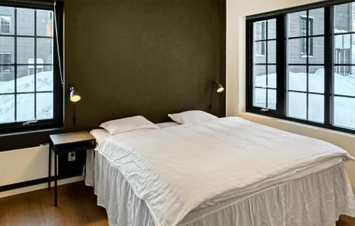 a bedroom with a large white bed with two windows at 2 Bedroom Lovely Apartment In Idre in Idre