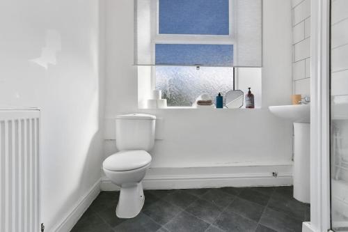 Baño blanco con aseo y lavamanos en Convenient 2-Bed Flat, Great for Workers & Small Groups - FREE Parking & Netflix, en Sheffield