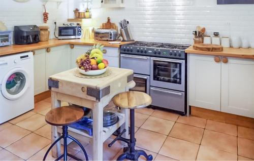 une cuisine avec une table avec un bol de fruits dessus dans l'établissement 4 Bedroom Amazing Home In Neuvic, à Neuvic