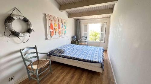 1 dormitorio con 1 cama, 1 silla y 1 ventana en Charmante villa face à la mer !, en La Flotte
