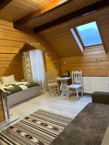 a room with a bed and a table and a window at Villa "Затишна" in Mykulychyn