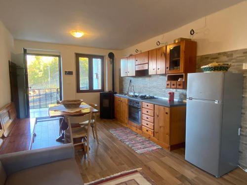 eine Küche mit einem weißen Kühlschrank und einem Tisch in der Unterkunft Il Sorriso - Appartamento con Grande Giardino e Barbecue in Gressan