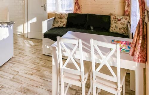 cocina con mesa blanca y 2 taburetes en Stunning Home In Chlopy With Wi-fi, en Chłopy