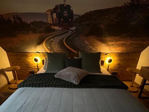 a bedroom with a bed with a train painting on the wall at Ferienhaus Harzglück in Bad Lauterberg