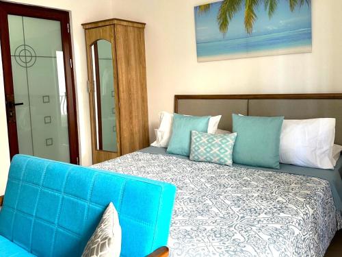 a bedroom with a blue bed and a blue couch at Residence Le Point Choisy in Pointe aux Canonniers