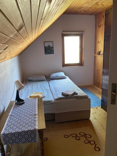 a bedroom with a bed with a wooden ceiling at Lasica in Žabljak