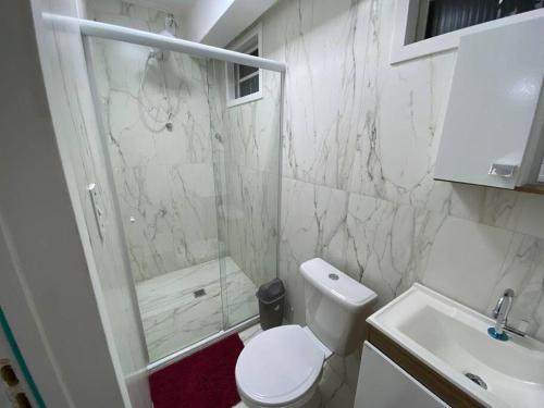 a bathroom with a shower and a toilet and a sink at Loft no Espinheiros - Joinville/SC in Joinville