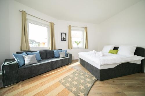 a living room with a bed and a couch at Deluxe Apartments - 1 & 2 Bedroom - Zentral - 10 Min Messe in Düsseldorf