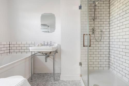 a white bathroom with a sink and a shower at The Putney Villa in London