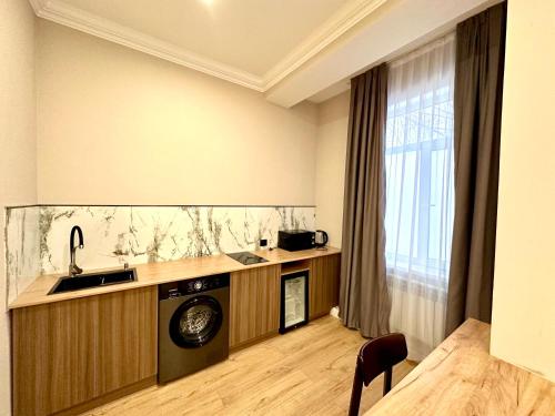 a kitchen with a washer and dryer in a room at Freedom hotel in Almaty