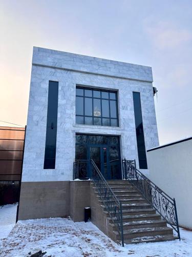 a building with a door and stairs in the snow at Freedom hotel in Almaty