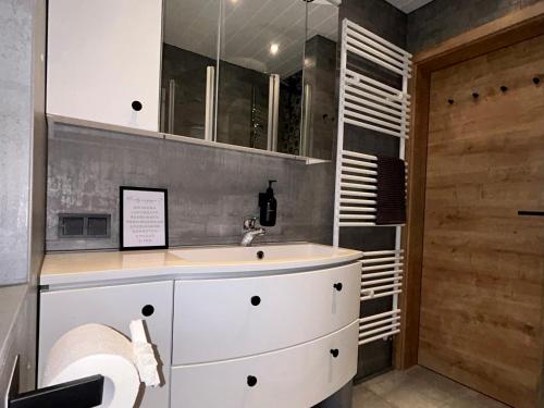 a white bathroom with a sink and a shower at Ferienhaus Harzglück in Bad Lauterberg